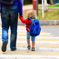 father with little daughter walking to school