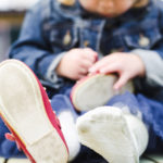 Baby girl plays with her shoes