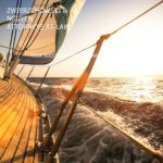 A boat sailing on the ocean at sunset.