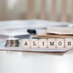 A table with some money and blocks that spell out " alimon ".