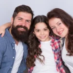 A man and two women with their arms around each other.