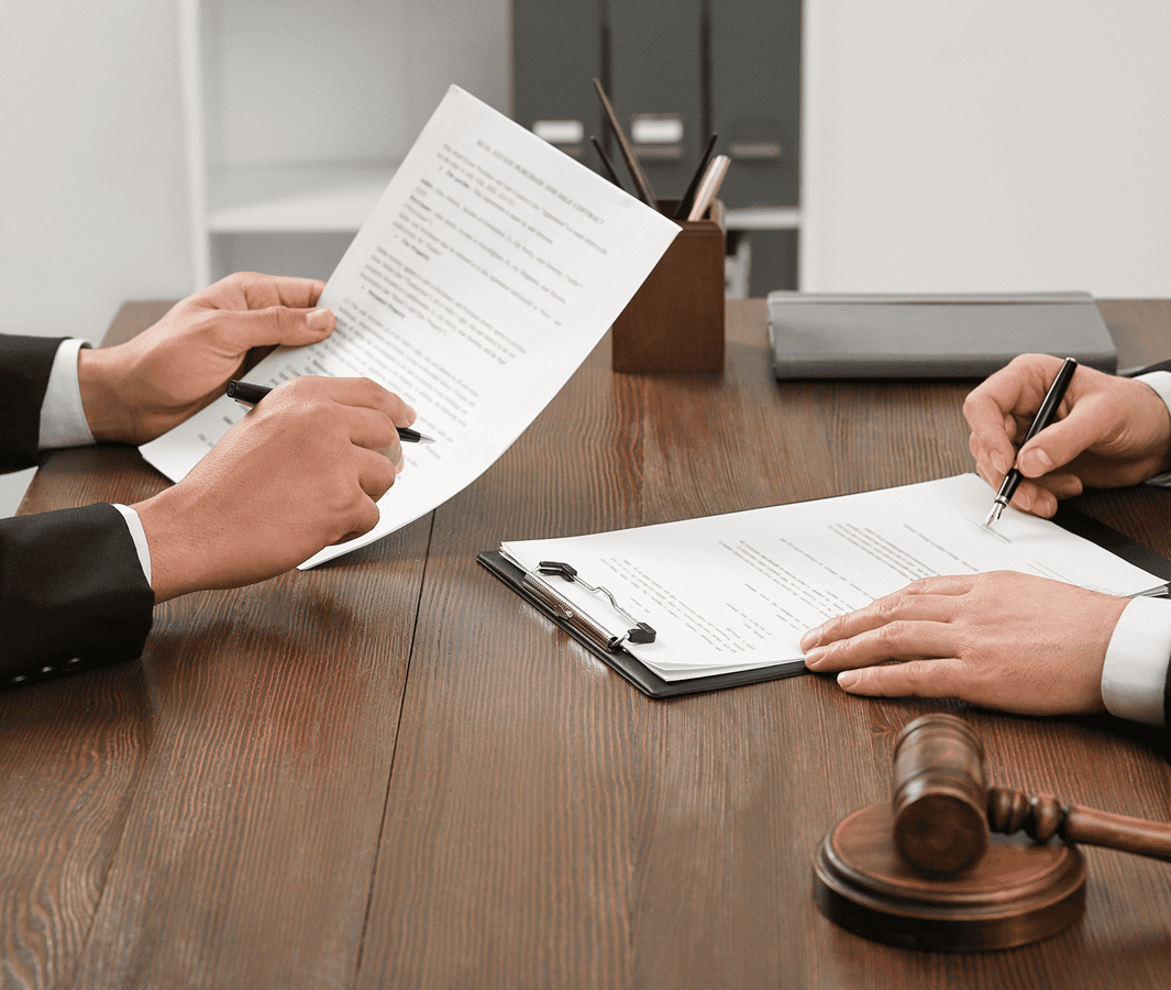 Two people reviewing and signing documents.