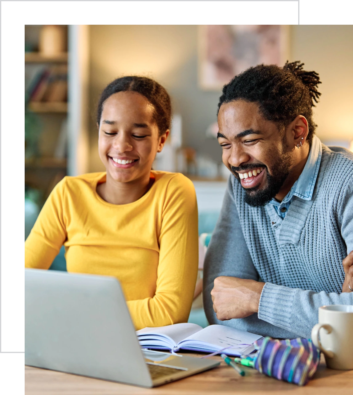Father and daughter laughing while studying together.