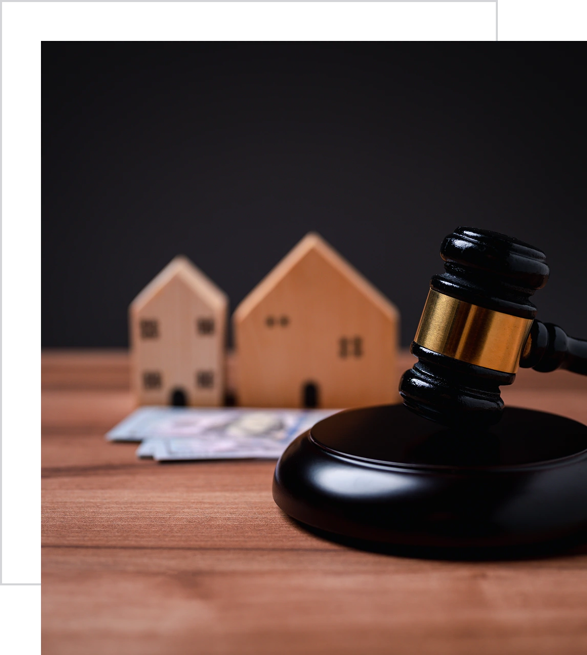 Gavel with miniature houses and money.