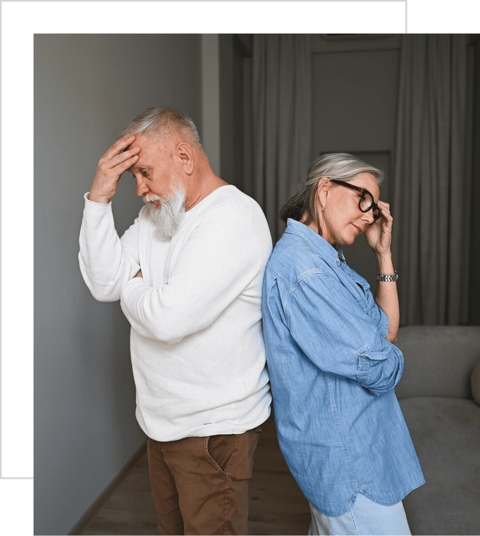 Elderly couple standing back to back, upset.