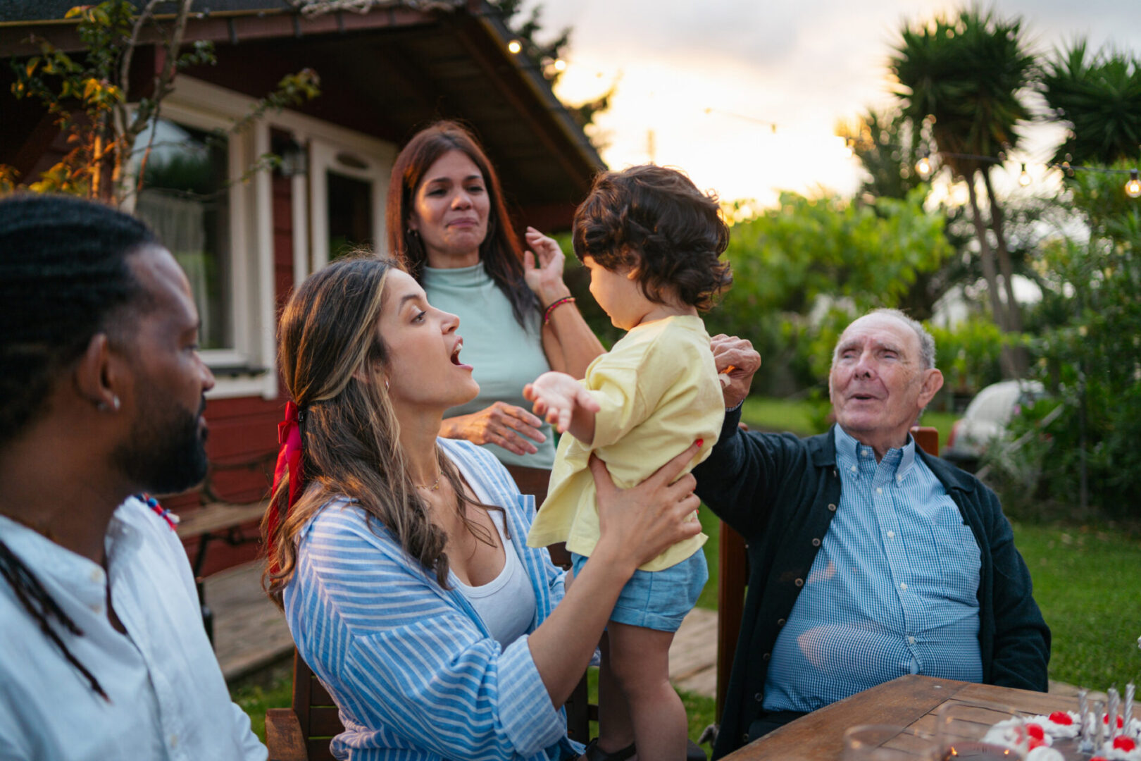 Multigenerational family gathered outdoors around a table